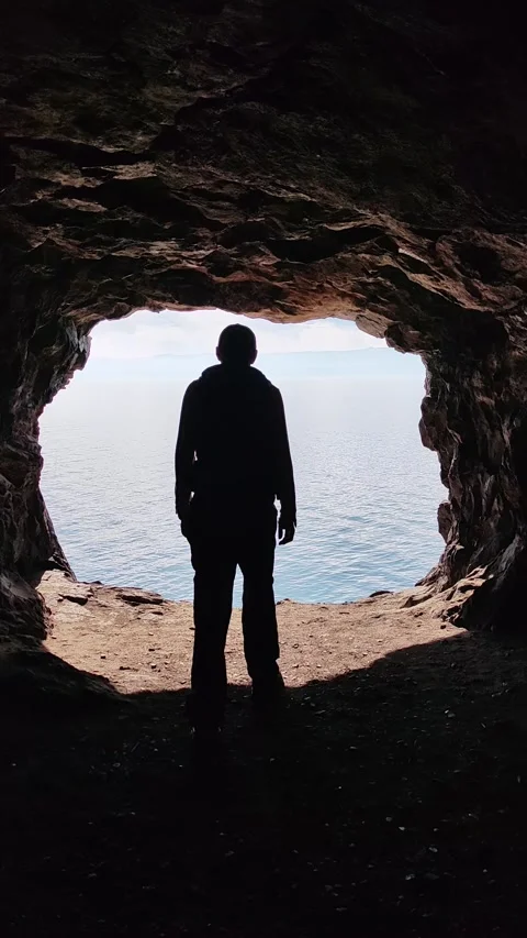 Adventurous man exploring sea cave standing at entrance. 스톡 동영상 335389756