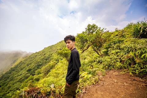 Adventurous Man Facing Camera on Top of Mountain. Spectacular Mountain Scener Stock Photos