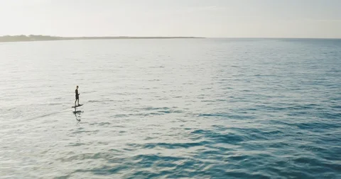 Adventurous man hydrofoiling at sunrise Stock Footage 125443560