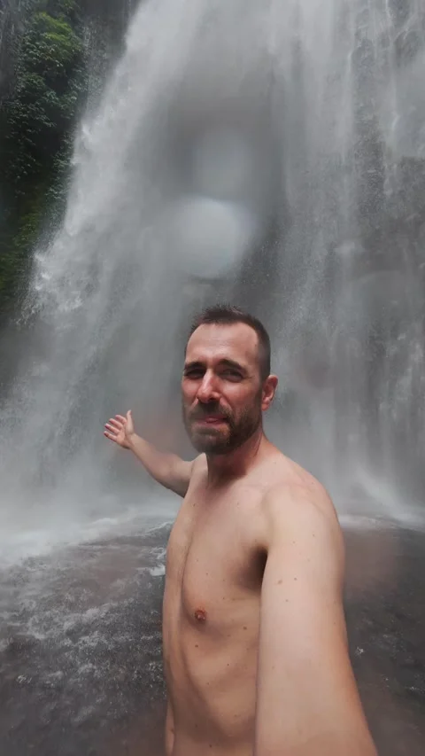 Adventurous man taking selfie under waterfall Stock Footage 318107458