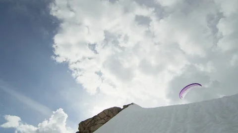 Adventurous paraskier speed flying from the snowy mountain cliff Stock Footage 116743573