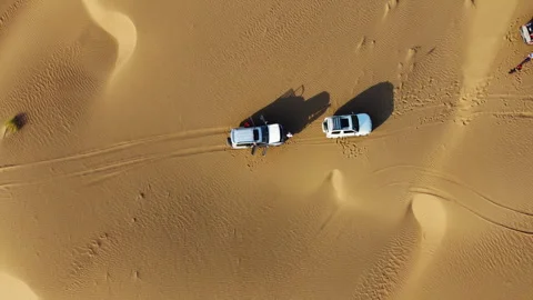 Adventurous Off-Road Vehicles Racing Through Desert Dunes at Golden Sunset Video stock 305527233