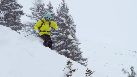 Adventurous skier making turns while skiing down the snowy slope Stock Footage 116740713