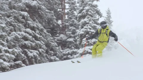 Adventurous skier making turns while skiing on snowy mountain slope Stock Footage 116785725