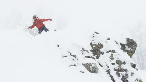 Adventurous snowboarder doing trick and sliding during a snowfall Stock Footage 116745677