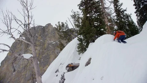 Adventurous snowboarder jumping down mountain and wiping out Stock Footage 116744625
