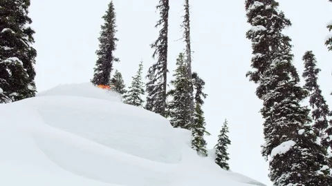 Adventurous snowboarder jumping downhill on steep snow mountain Stock Footage 116788669