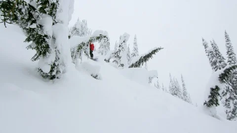 Adventurous snowboarder riding down very inclined slope on snowy mountain Stock Footage 116783040