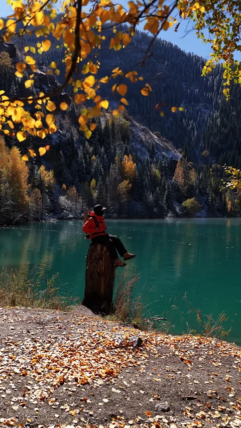 Adventurous tourist exploring a mountain Issyk's lake in autumn, Kazakhstan Stock Footage 344589514
