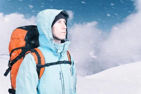 Adventurous young man with backpack standing on mountain top view and looking Stock Illustration