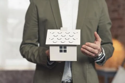 Advertisement entrepreneur developer presenting mini plastic house Stock Photos