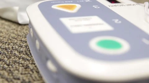 AED beeping and giving instructions to conduct CPR Stock Footage 200979219