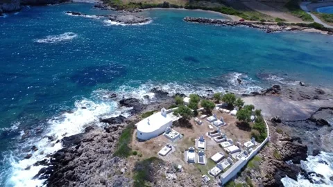 Aegean bay with waves hitting rocks and small Christian chapel Video stock 316624006