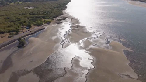 Aeral top down on inlet at low tide reflective water 4k drone Stock Footage 253345757