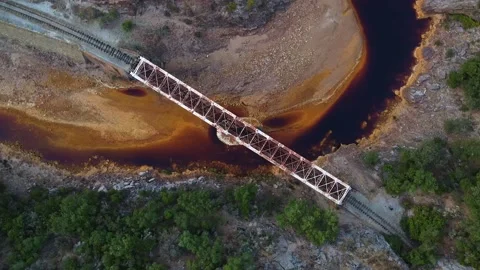 Aereal shot of a bridge over a red river of iron Stock Footage
