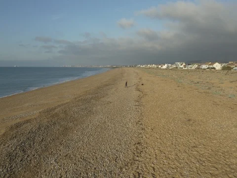 Aerial 2 of Man Walking Dog on Shoreham Beach, West Sussex, UK Stock Footage 78355201