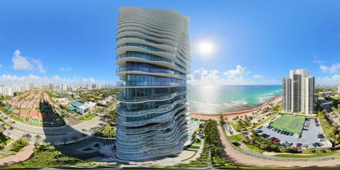 Aerial 360 8k rise between highrise towers on the beach Stock Footage 335607819