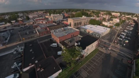 Aerial 360° view of Valley Stream, sunset by the Long Island Railroad station Stock Footage 345094123