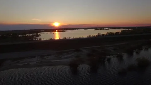 Aerial 4k copter fly of bridge near waters of river overflowing banks at sunset Stock Footage 77907565