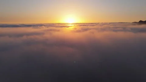 Aerial 4K Drone Flight Above Clouds at Sunset with Sun in Frame Relaxing Nature Stock Footage 314600700