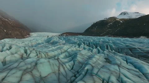 Aerial 4K drone flight forward over massive blue glacier crevasses in Iceland Vídeo Stock 332657024
