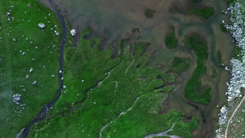 Aerial 4k drone video of a small lake with unique grass shape around Stock Footage 285944406