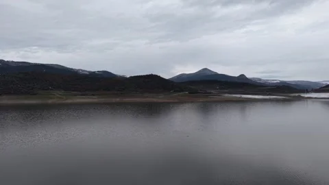 Aerial 4K Drone View of Calm Lake, Mountains and Overcast Sky Видео 341527281