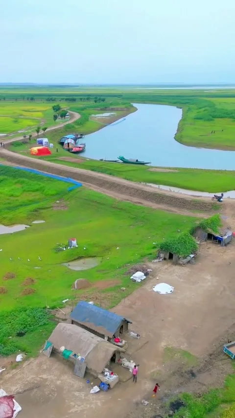 Aerial 4K Drone View of Green Village Fields and Winding River at Sunrise Stock Footage 321728995