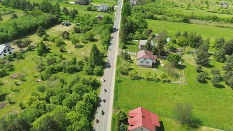 Aerial 4K Flyover of Motorcycle Column Riding Down Countryside Road in Polan Stock Footage 311025962