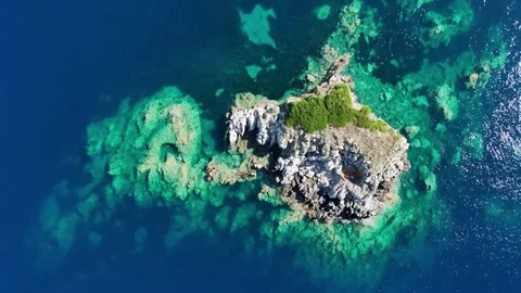 Aerial 4K top down shot of small rocky island surrounded by turquoise ocean wate Stock Footage 340568153