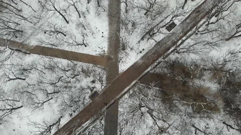 Aerial 4k top down view of the park with snow-covered paths and walking people Stock Footage 150368395