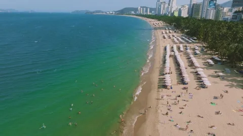 Aerial 4K view of crowded Nha Trang beach with tourists sunbathing Vietnam Stock Footage 333578793