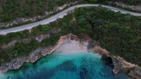 Aerial 4K view of hidden beach cove beneath coastal road in Sivota Ionian Sea Gr Stock Footage 340569718