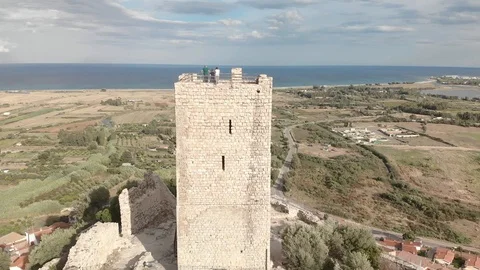 Aerial 4k view of tower castle and medieval town with valley and sea - Posada Stock Footage 125873016
