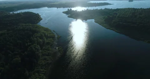 Aerial  Above Evening Setting Sun Reflecting Light Between The Land And Lake Stock Footage 187935487
