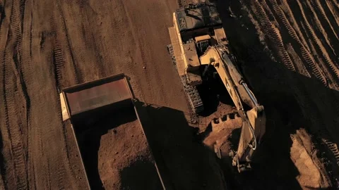 Aerial above excavator loading a dump truck with dirt on a construction site Stock Footage 130667676