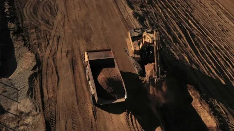 Aerial above excavator loading a dump truck with dirt on a construction site Stock Footage 130667699