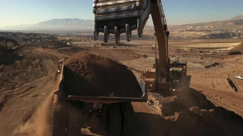 Aerial above excavator loading a dump truck with dirt on a construction site Stock Footage 130667728