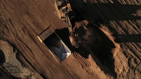 Aerial above excavator loading a dump truck with dirt on a construction site Stock Footage 146924167