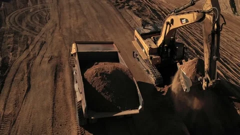 Aerial above excavator loading a dump truck with dirt on a construction site Stock Footage 146924463
