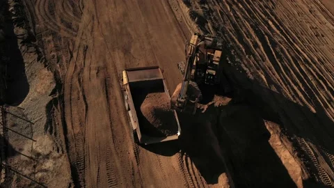 Aerial above excavator loading a dump truck with dirt on a construction site Stock Footage 147358771