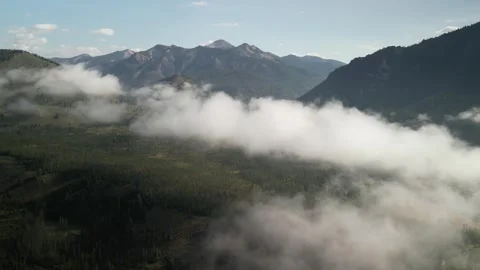 Aerial above low clouds in Sawtooth Mountains in Stanley Idaho in summer Stock Footage 280207752
