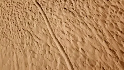 Aerial above sand dune pattern at the desert. Fly over desert landscape with Stock Footage 145532542