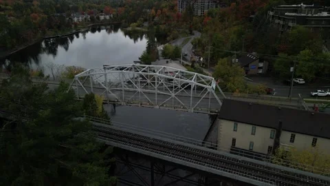 Aerial above train track bridge and Muskoka River in Bracebridge Ontario Canada Stock Footage 318566862