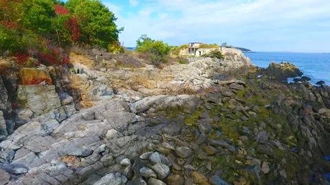 Aerial across waves crash into patch of rocky coastline in Maine Vídeos de archivo 225788171