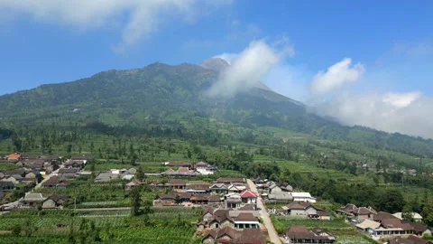 Aerial of active Merapi volcano and picturesque village on its slope Indonesia Stock Footage 281407029