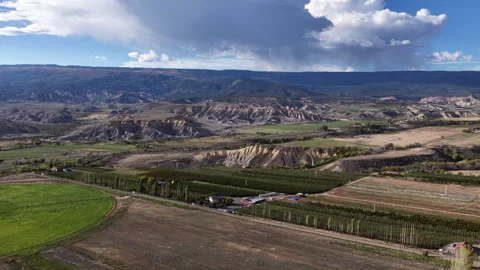 Aerial of agricultural fields and eroded badlands terrain in Eckert Colorado 動画素材 347312596