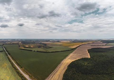 Aerial Agricultural Fields Under Cloudy Sky Stockfoto's