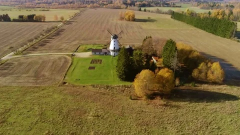 Aerial approach to a historic windmill between golden fields in autumn Stock Footage 82118456