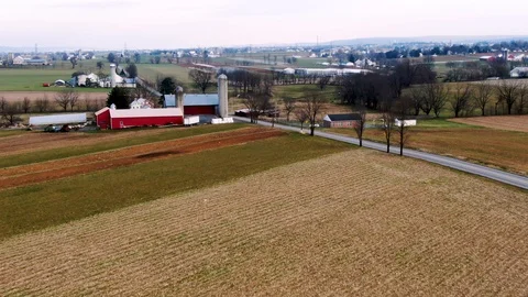 Aerial approach over a patchwork of brown and green fallow fields to an Video stock 105474653
